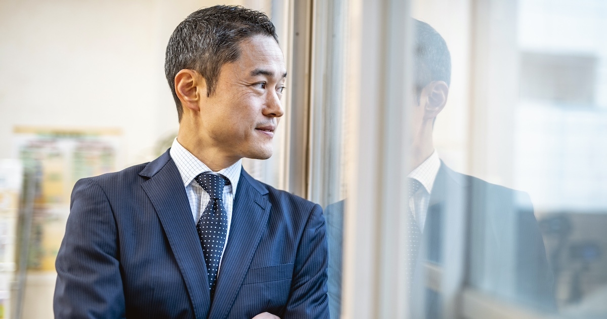 窓の外を見つめるビジネスマン
