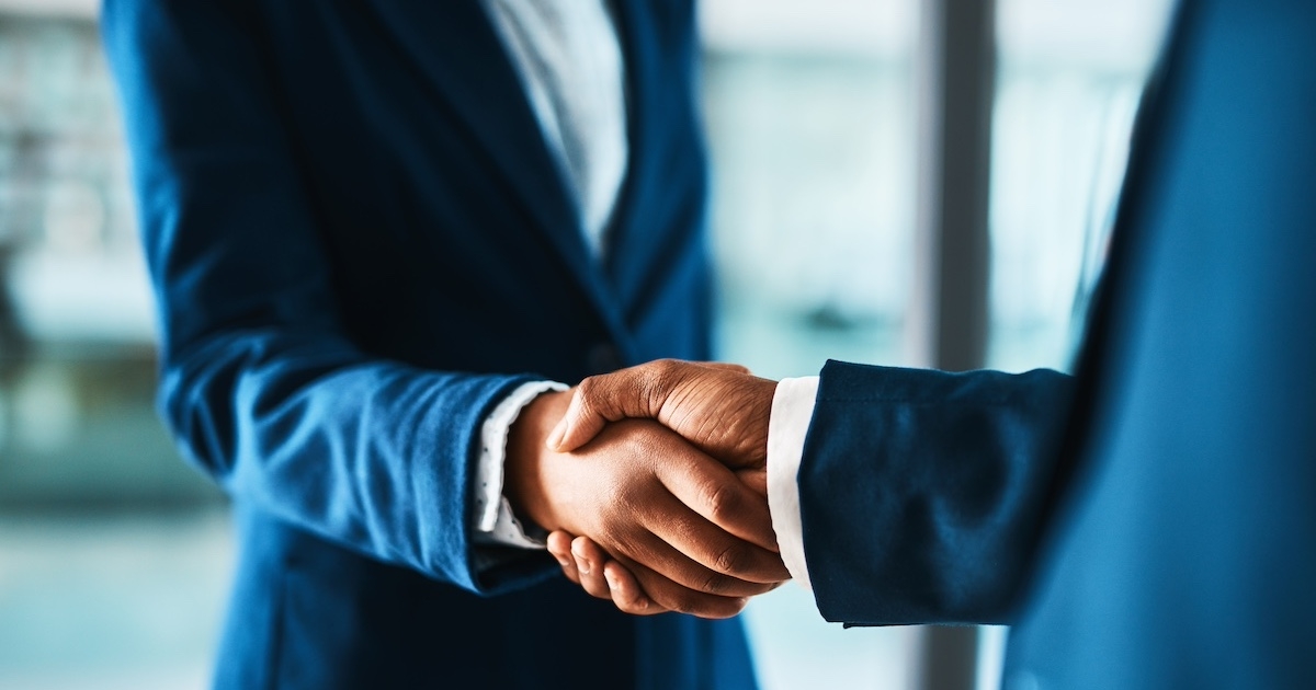 握手をするビジネスマンの手元
