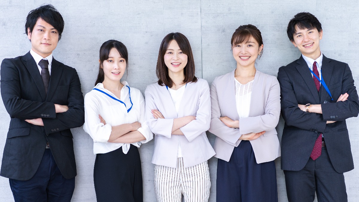 笑顔で腕を組んでいる男女5人