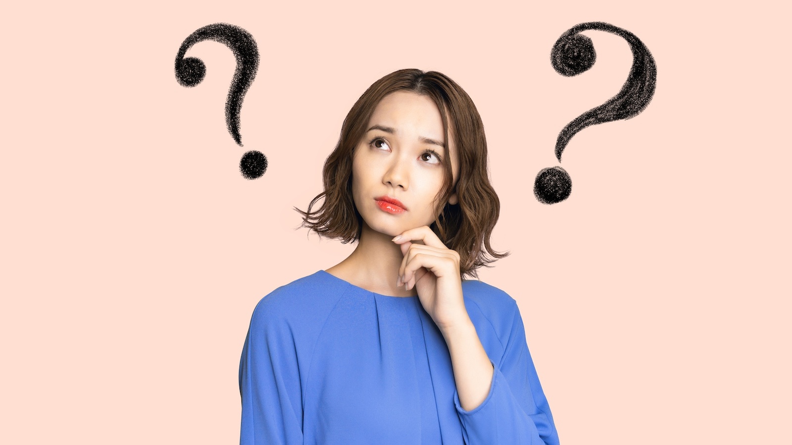 頭の横に疑問符が浮かぶ女性