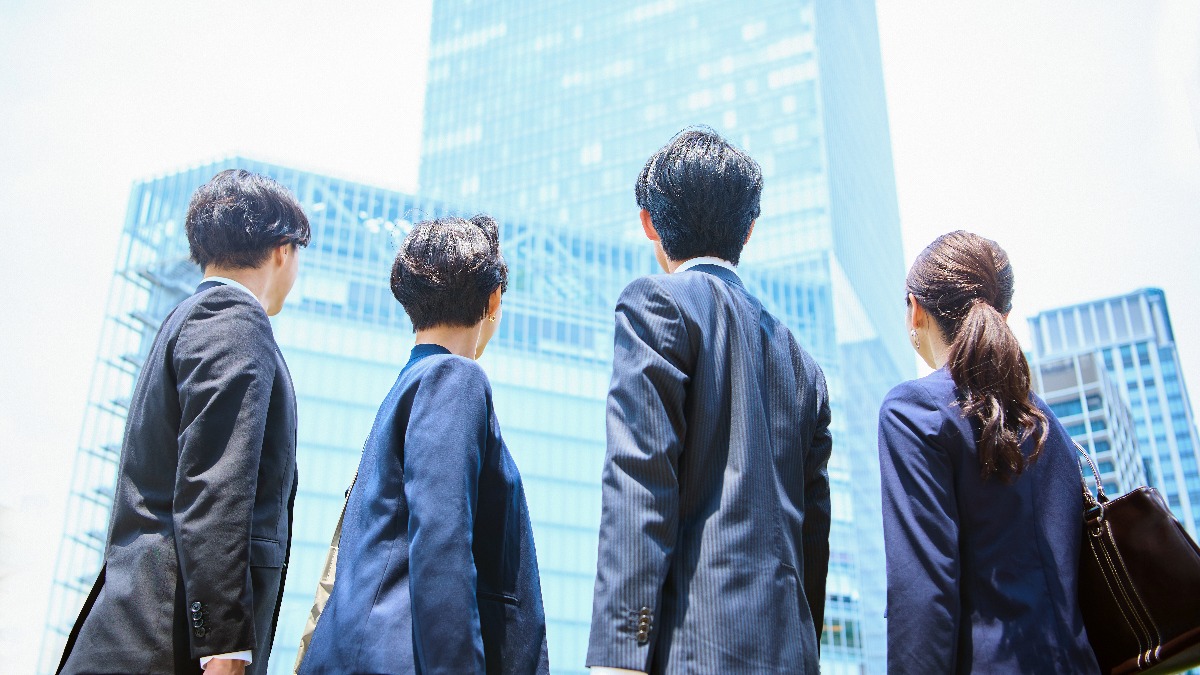 高層ビルを見上げる男女4人