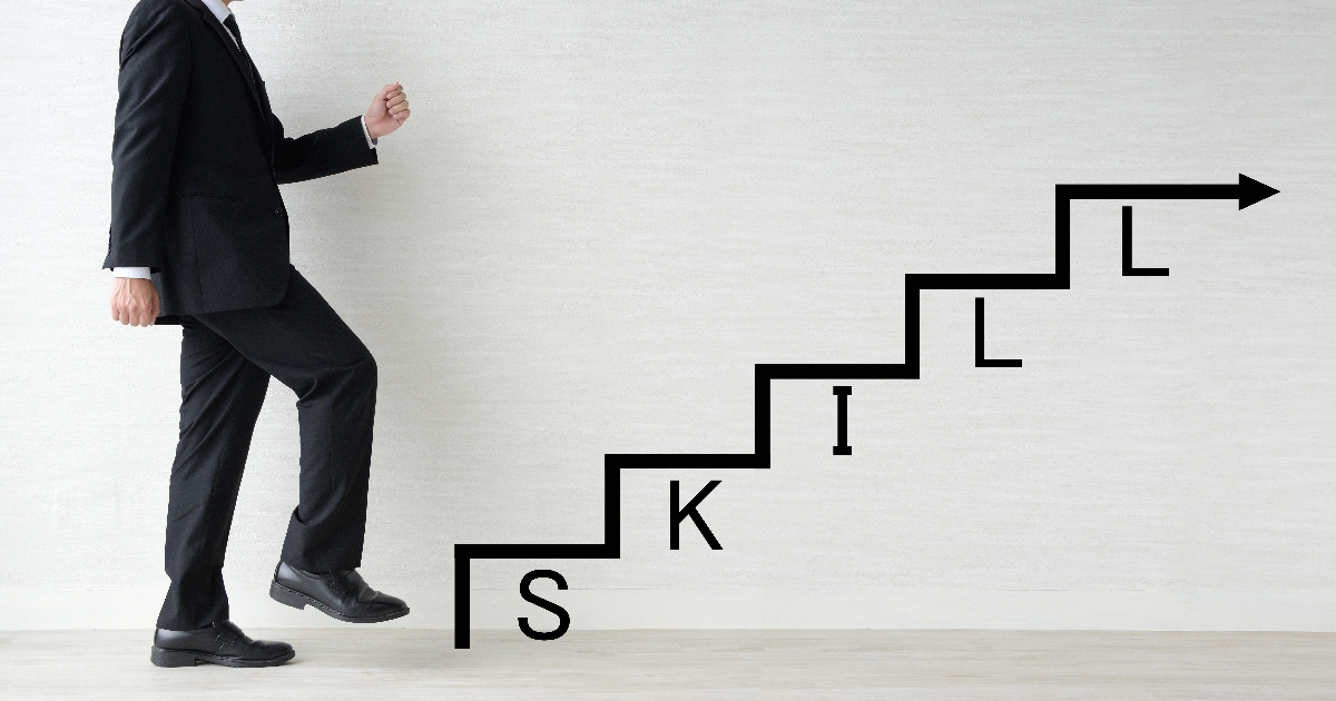 SKILLと書かれた文字の階段を登ろうとする男性