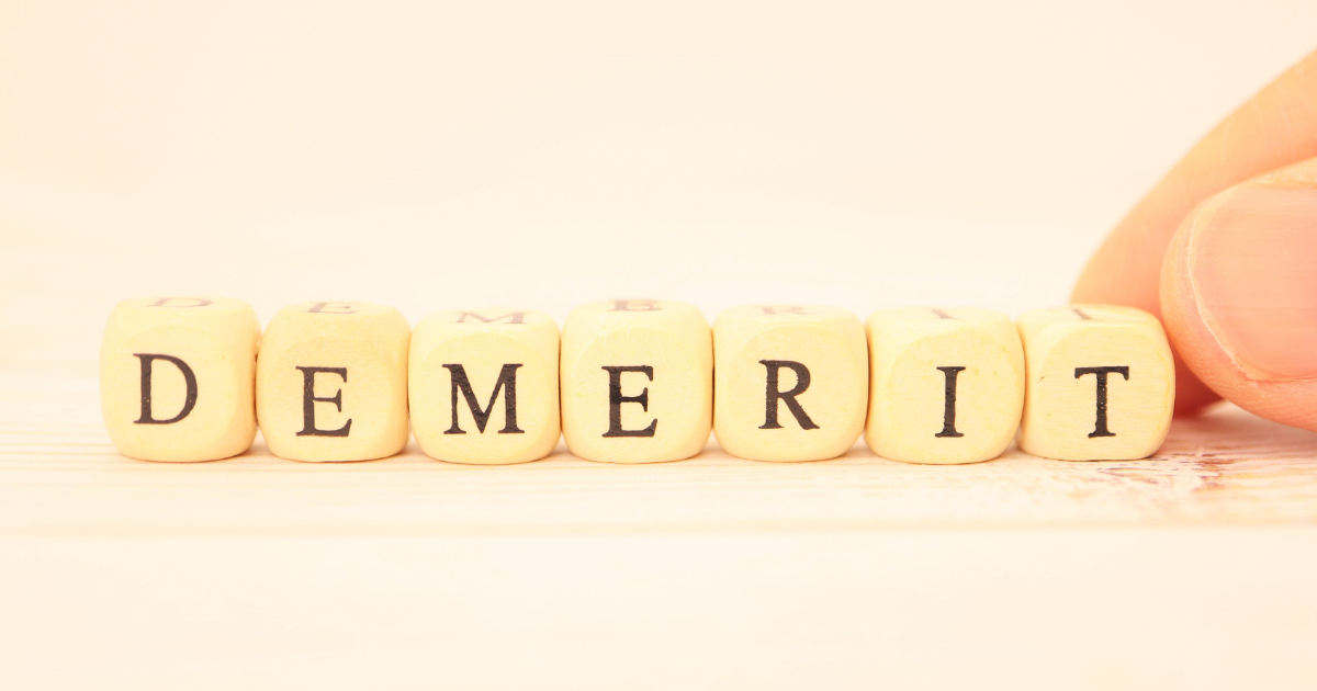 「DEMERIT」と書かれたアルファベットレター