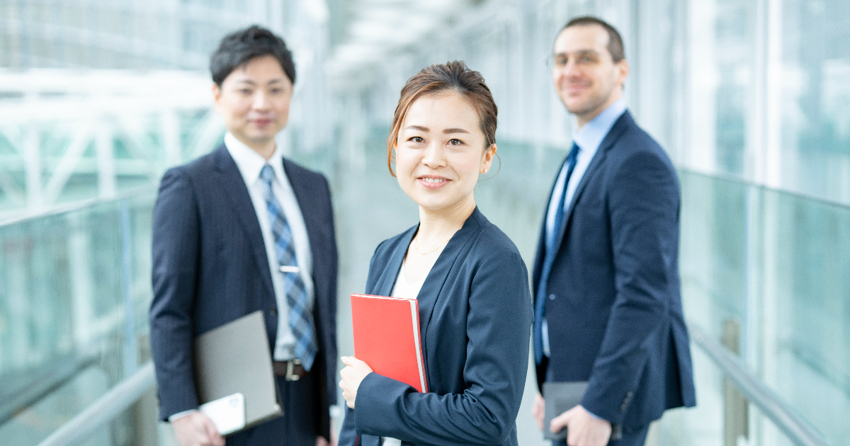 書類を手に持ち正面を向く3人のビジネスマン