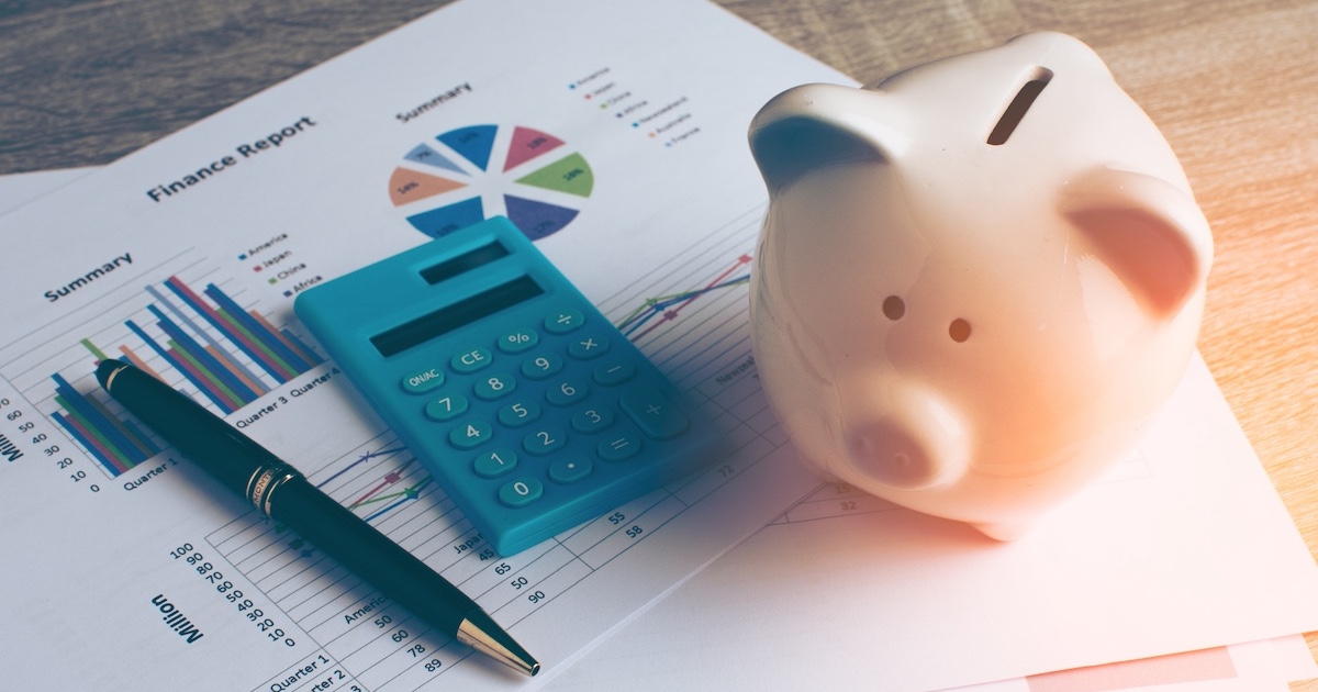 資料の上に電卓と豚の貯金箱