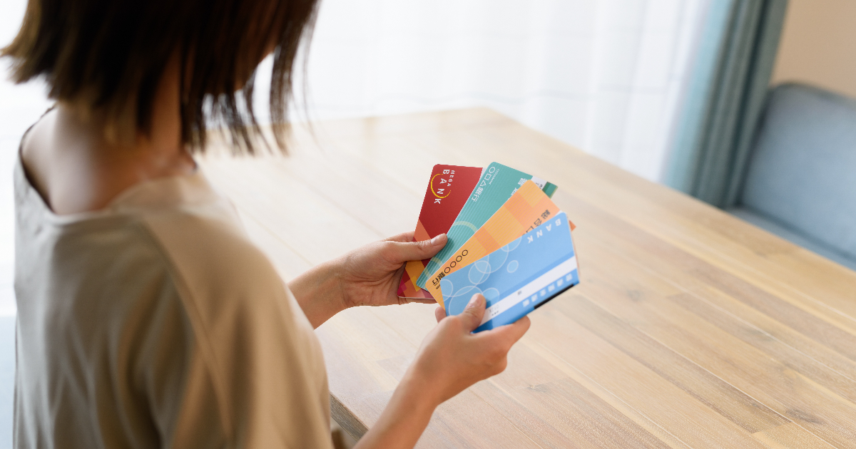 複数の通帳を手に持つ女性