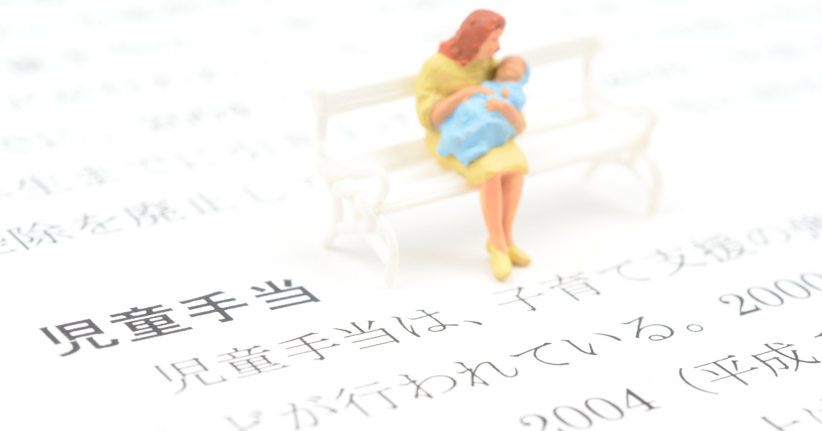 児童手当と書かれた書類と親子のフィギュア