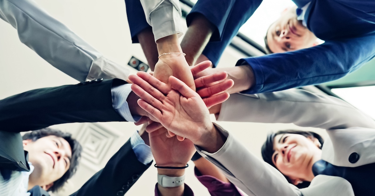 円陣を組むビジネスパーソン