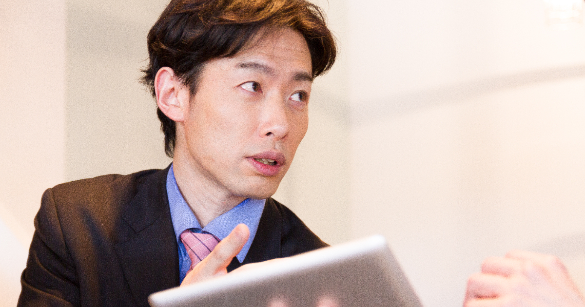 タブレットを手に説明するビジネスマン