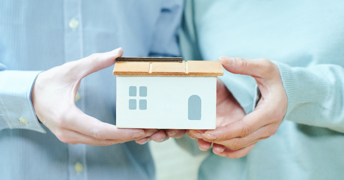 家の模型を一緒に持つ男女