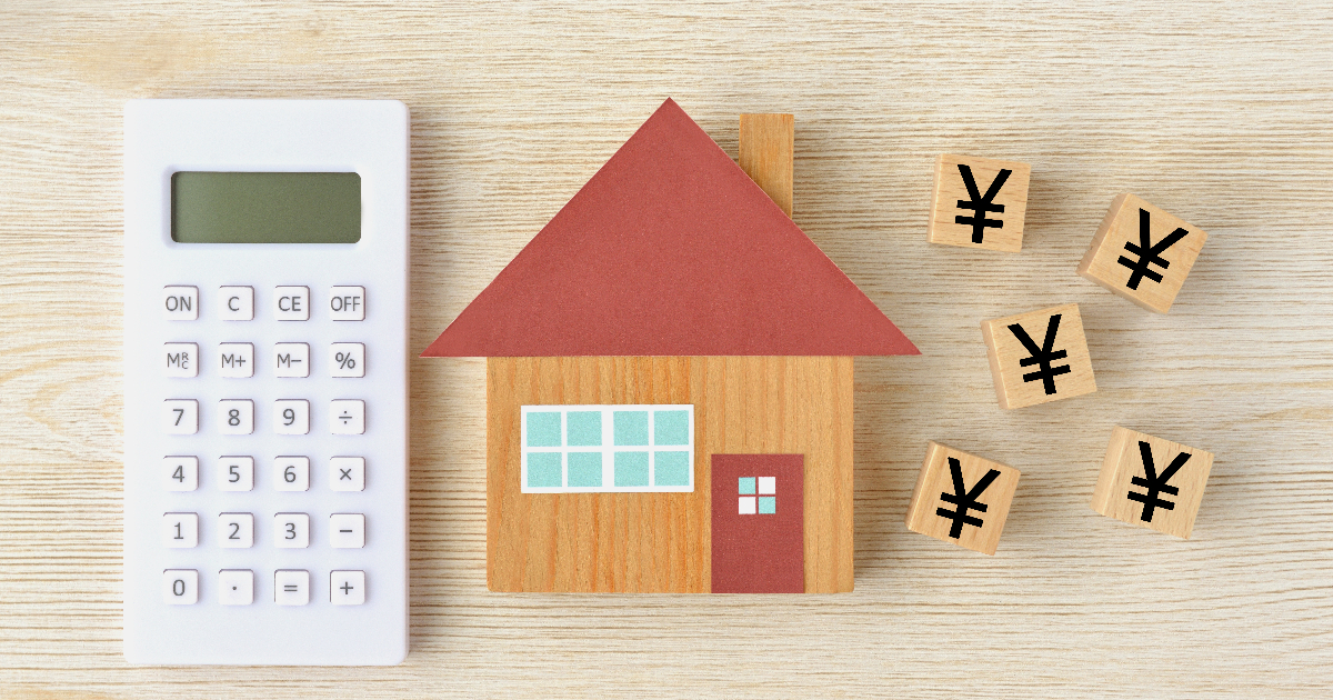 家の模型と電卓、￥マークの積み木