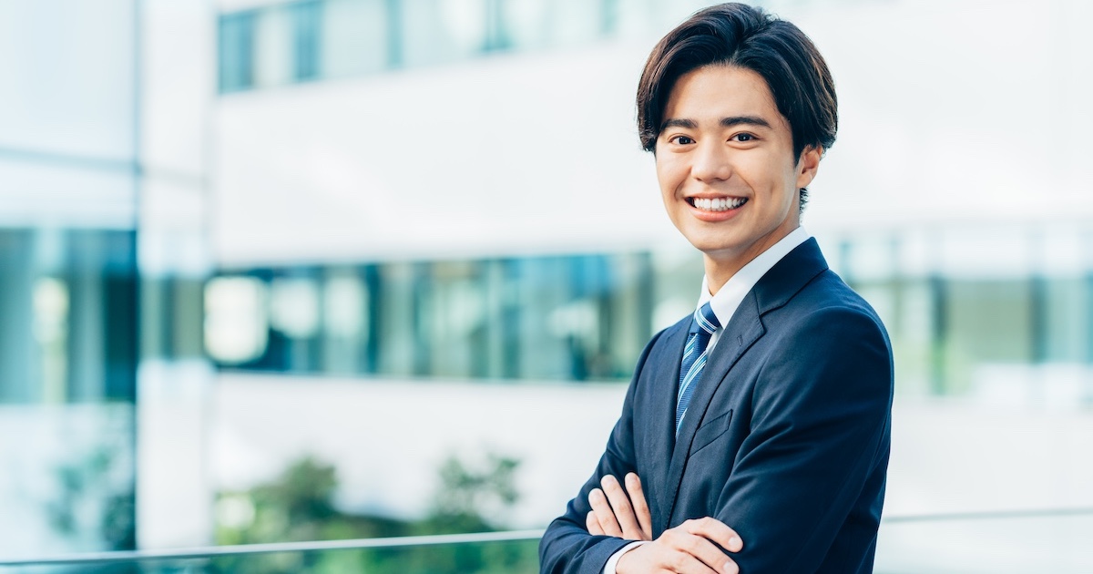 腕を組み笑顔のビジネスパーソン