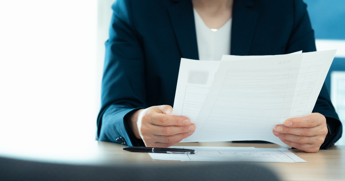 書類を手に持ち確認する女性