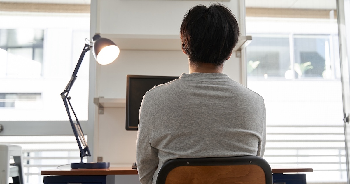 デスクに座るビジネスパーソンの後ろ姿