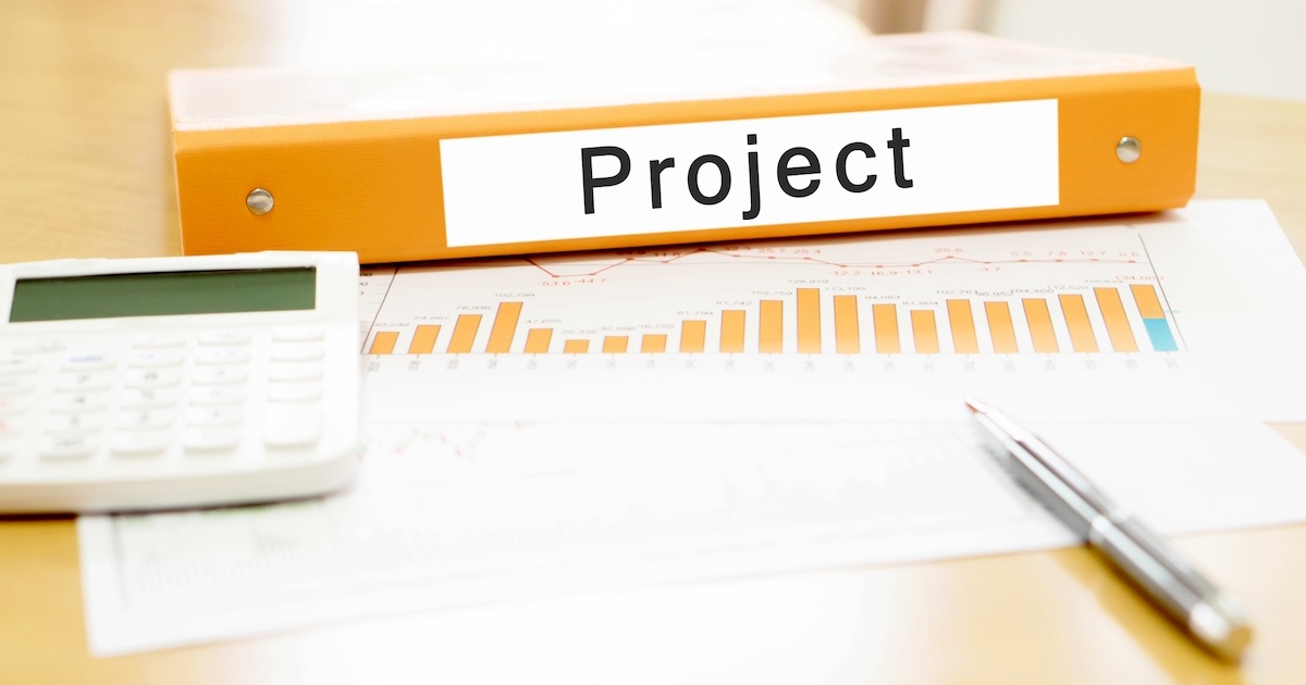 プロジェクトについてまとめている様子、デスクの上のファイルと資料