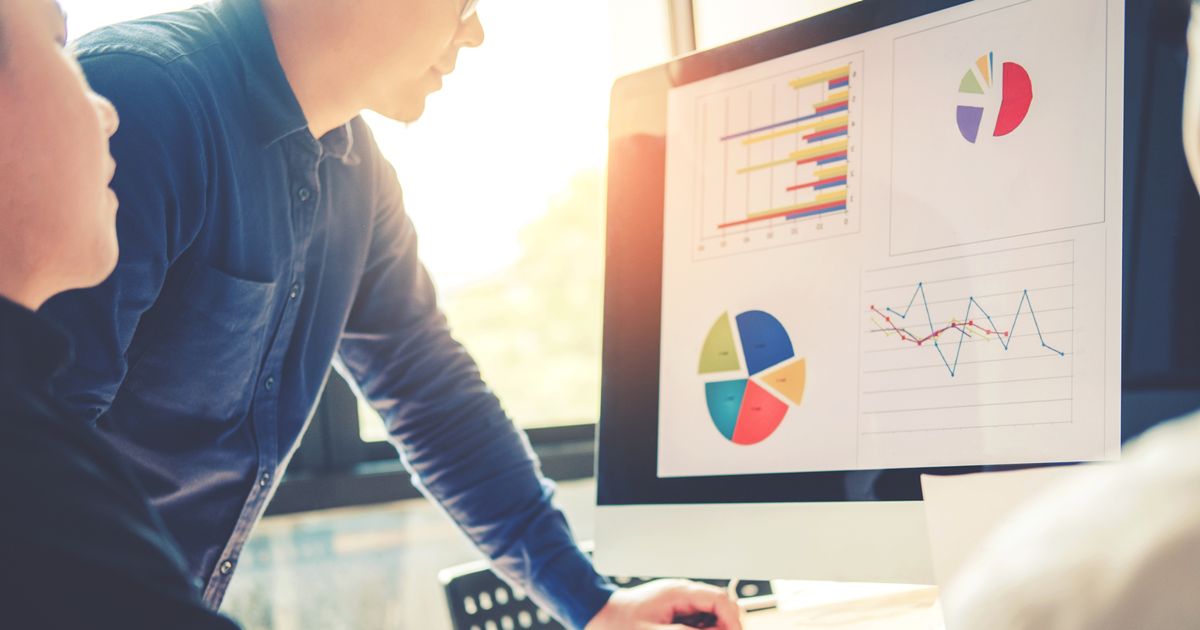 パソコン画面を見る3人の男性