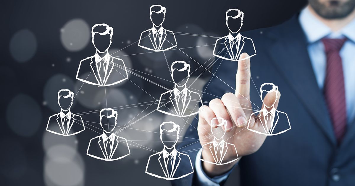 複数の人物イラストを指すスーツ姿の男性の手