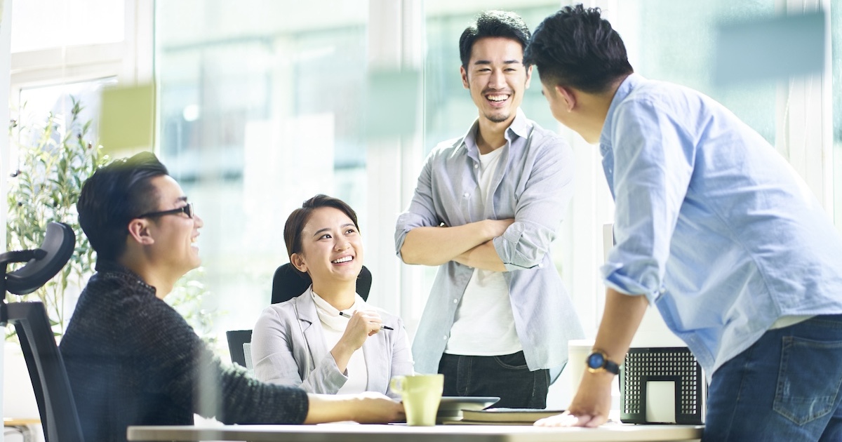 笑顔でミーティングをする4人のビジネスパーソン