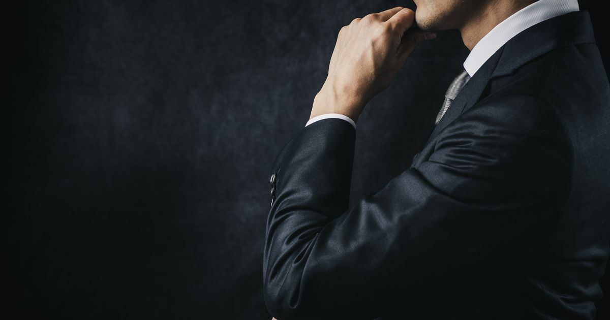 顎に手を当てて考える男性の上半身