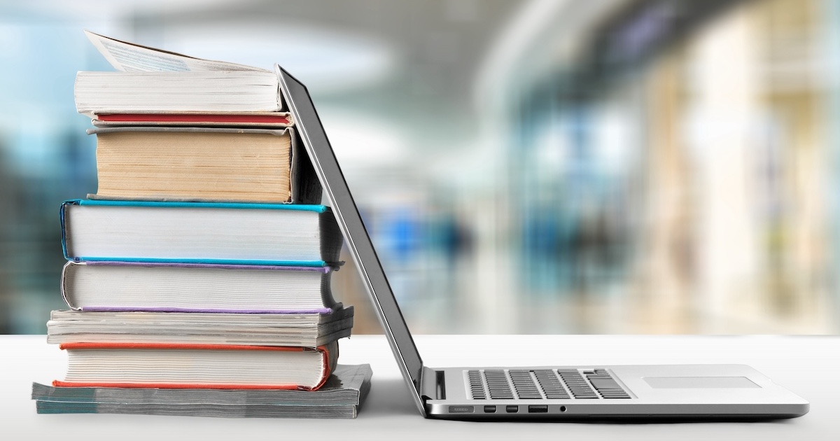 デスクの上のPCと積まれた本