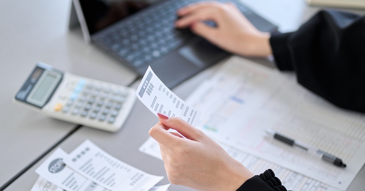 レシートを手にパソコンに打ち込む手元
