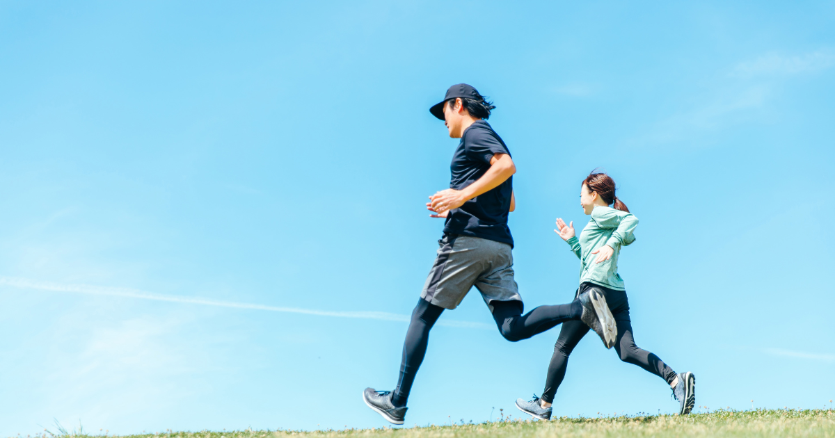早朝に屋外でランニングをする男女