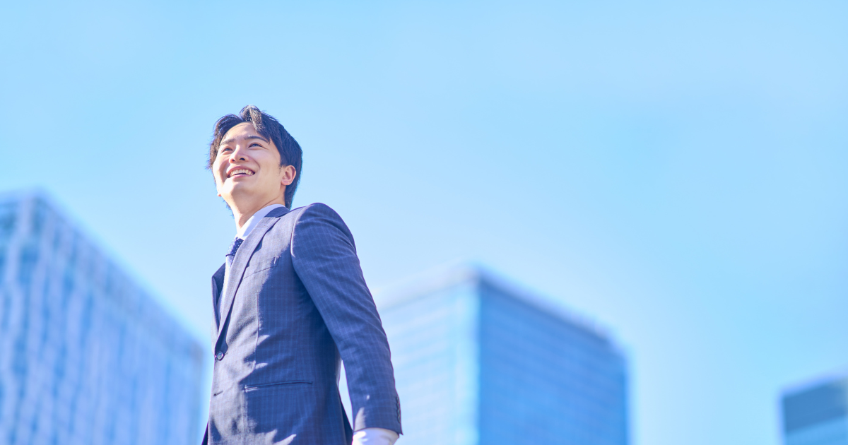 朝の空の下で前向きに歩くビジネスパーソン