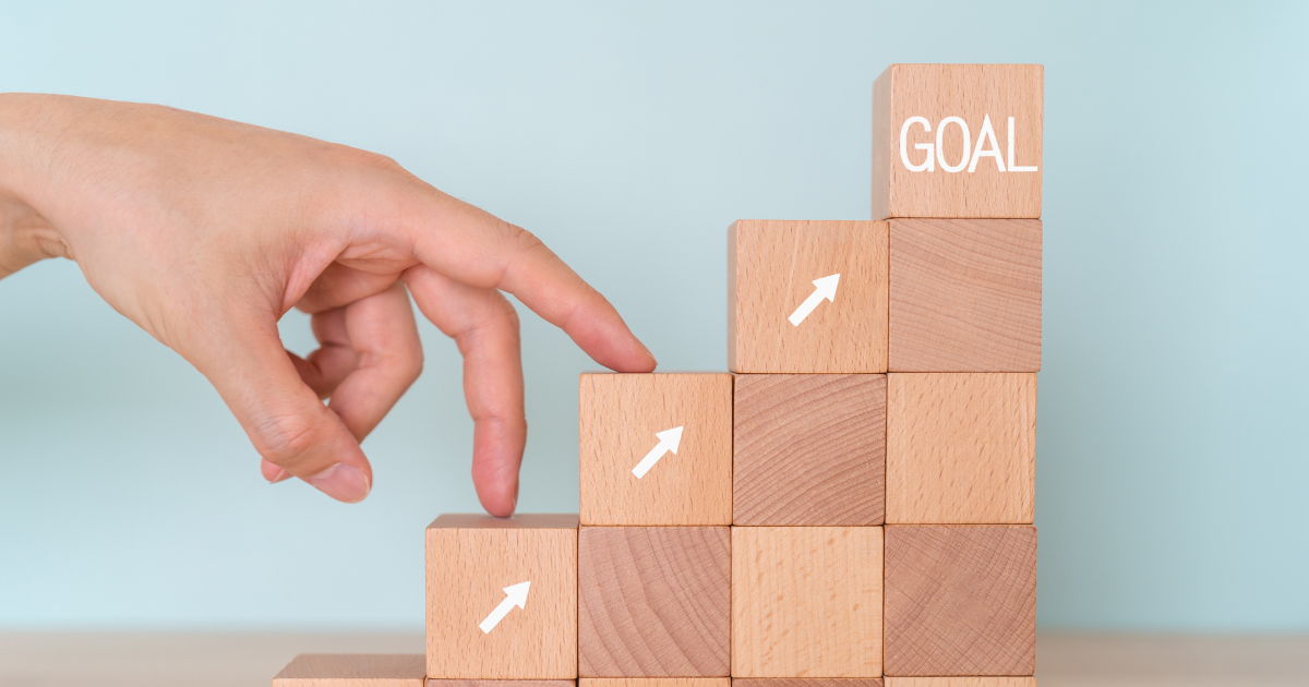 「GOAL」と書かれた積み木と積み木を登る指