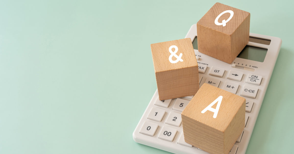 電卓の上に「&」「Q」「A」と書かれた木製キューブ