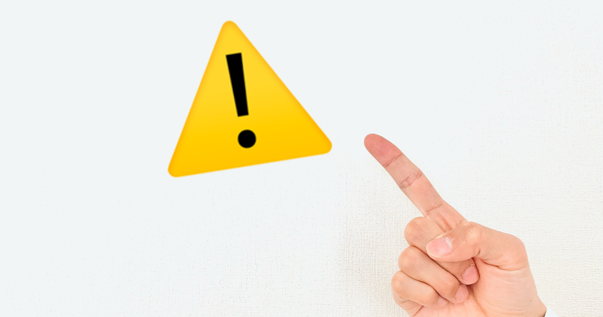 黄色い警告マークを人差し指が指し示している様子
