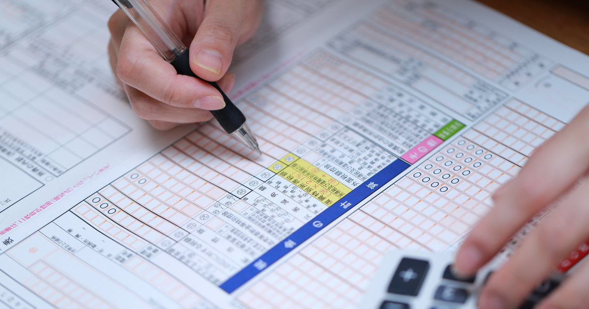 確定申告の書類にペンで記入しようとしている手元の様子