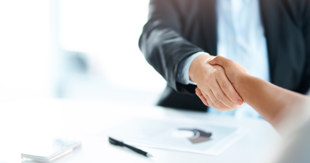スーツ姿の人物が握手をしている様子