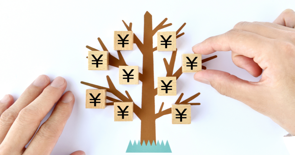 木のイラストに円マークが描かれた木製ブロックを並べる手