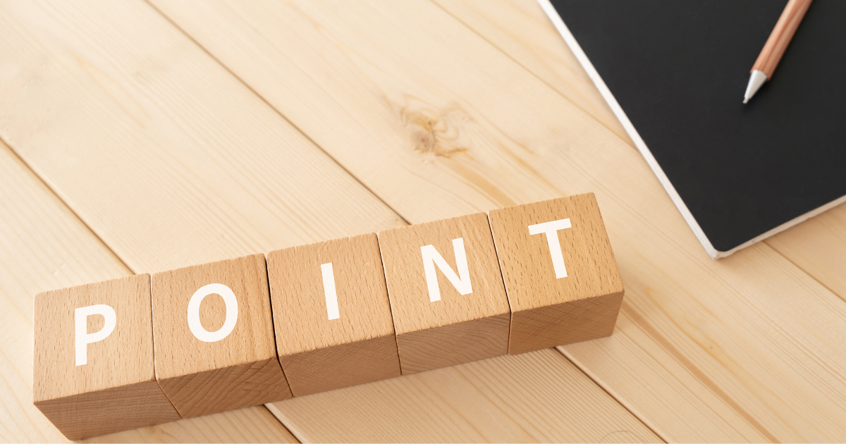 木のキューブに「POINT」の文字が並び、横にノートと鉛筆がある