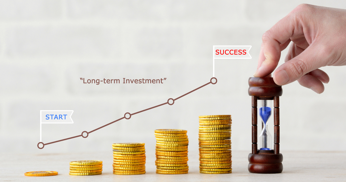 コインが積み上げられた前で、右肩上がりのグラフと砂時計が配置されている様子