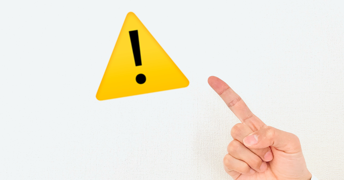注意や警告を示す黄色の三角形アイコンを、人差し指で示している様子