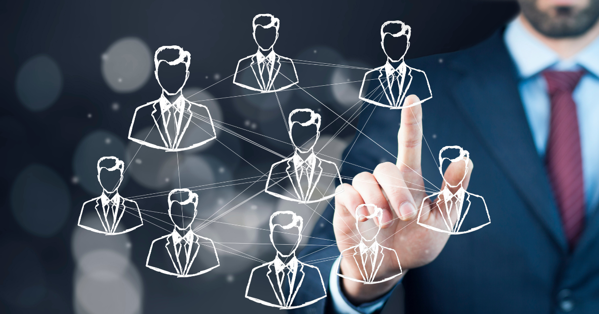 人材や組織を示すアイコンが浮かぶデジタル画面を操作する、ビジネスパーソンの手
