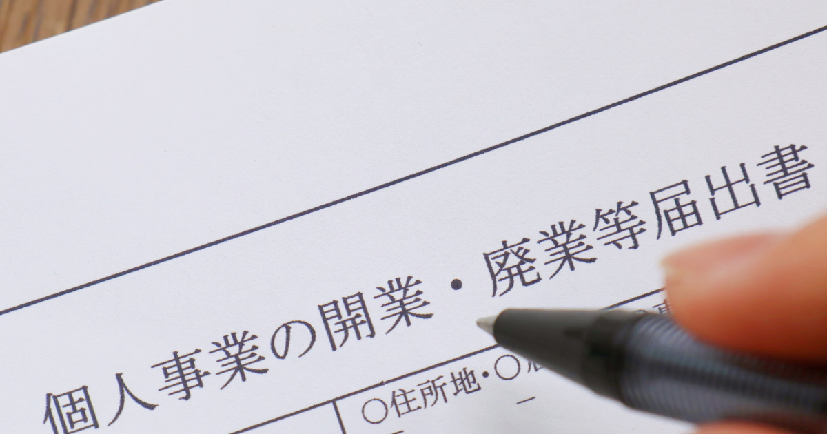 個人事業の開業・廃業等届出書にペンで記入する手元