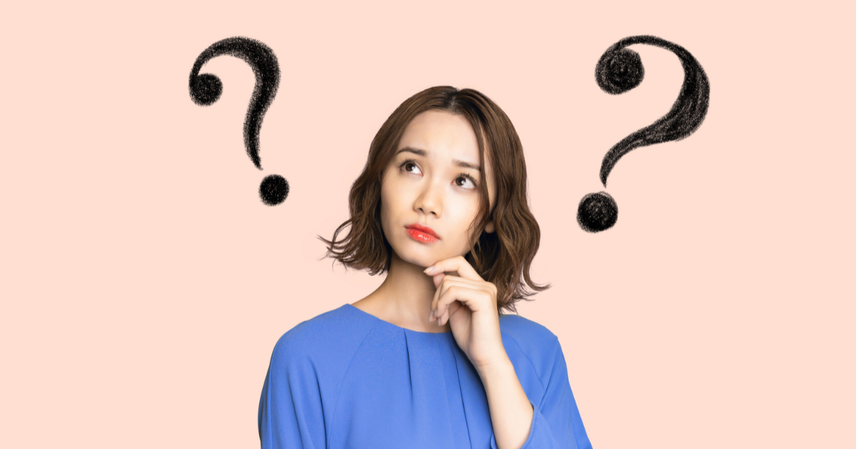 疑問の表情で考えている女性とクエスチョンマークのイメージ