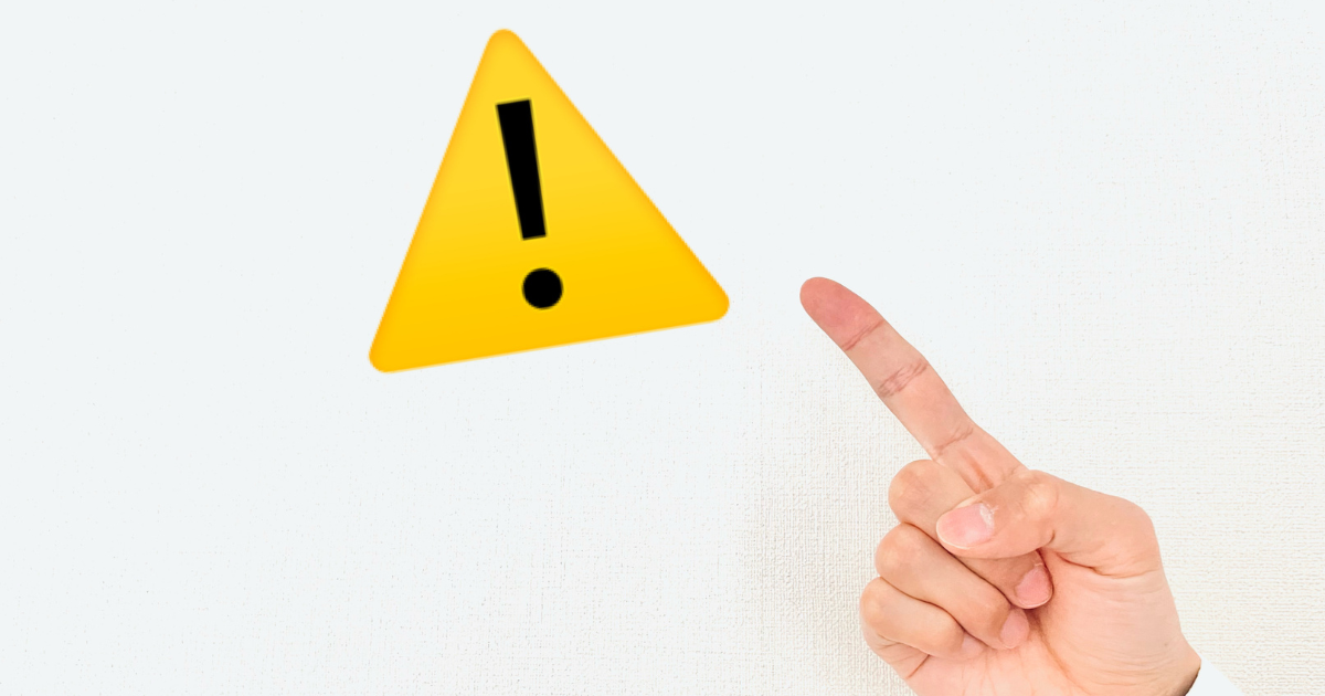 黄色い警告マーク（ビックリマーク）を指差す手