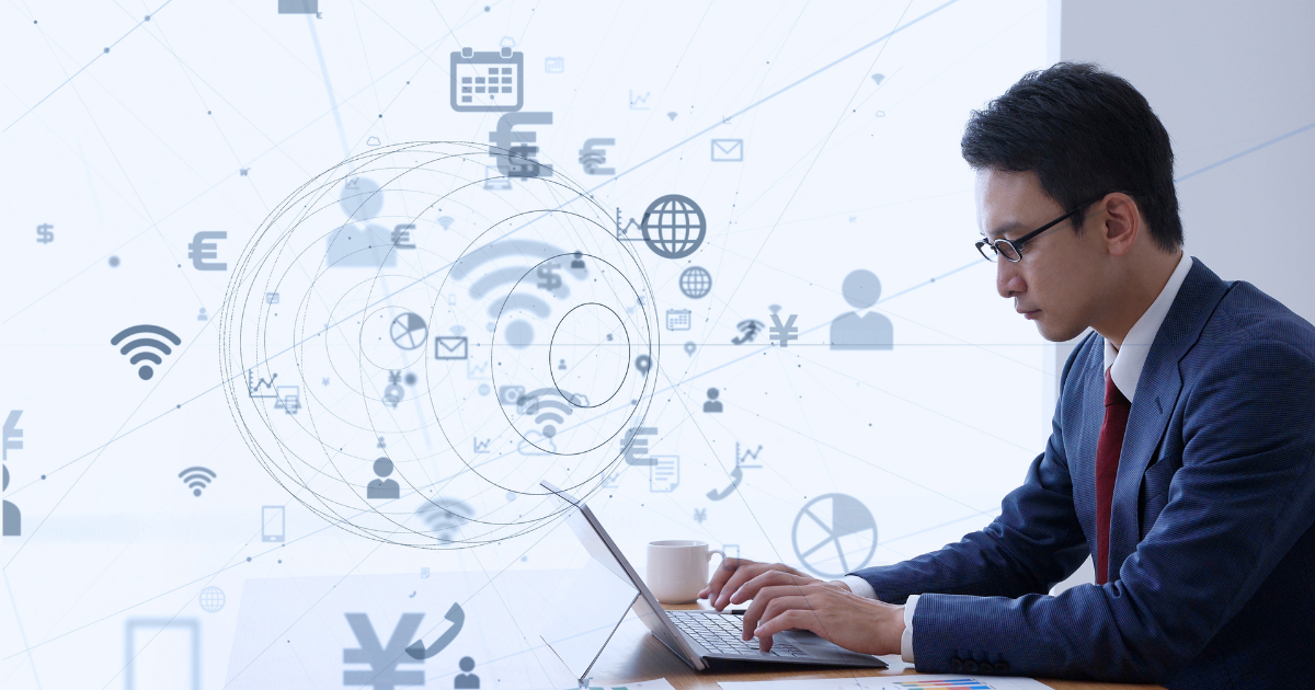 ノートパソコンを操作するスーツ姿の男性とネットワークのイメージ