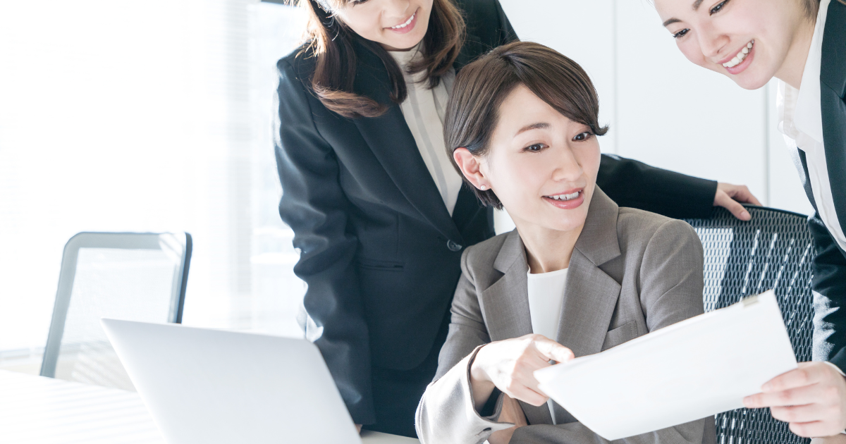 書類を見ながら話し合うビジネスパーソンたちの写真