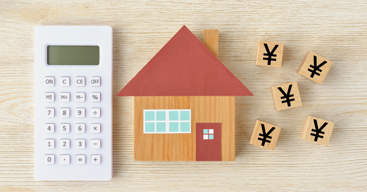 家の模型と電卓、円マークが書かれた複数の積み木