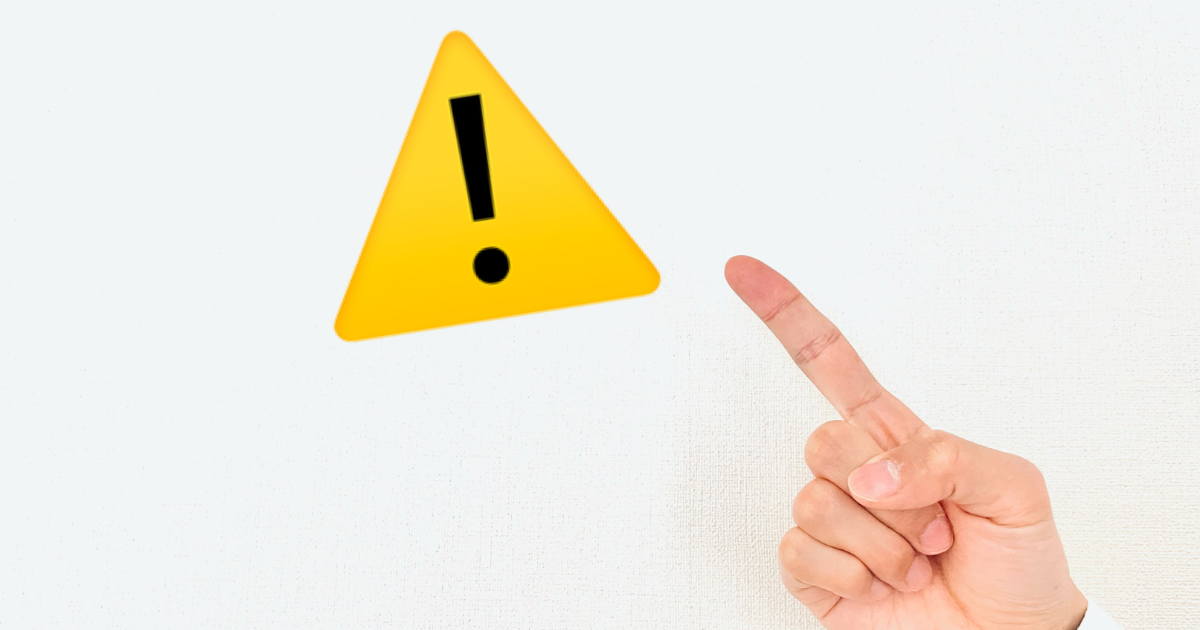 黄色い警告マークを指差す手
