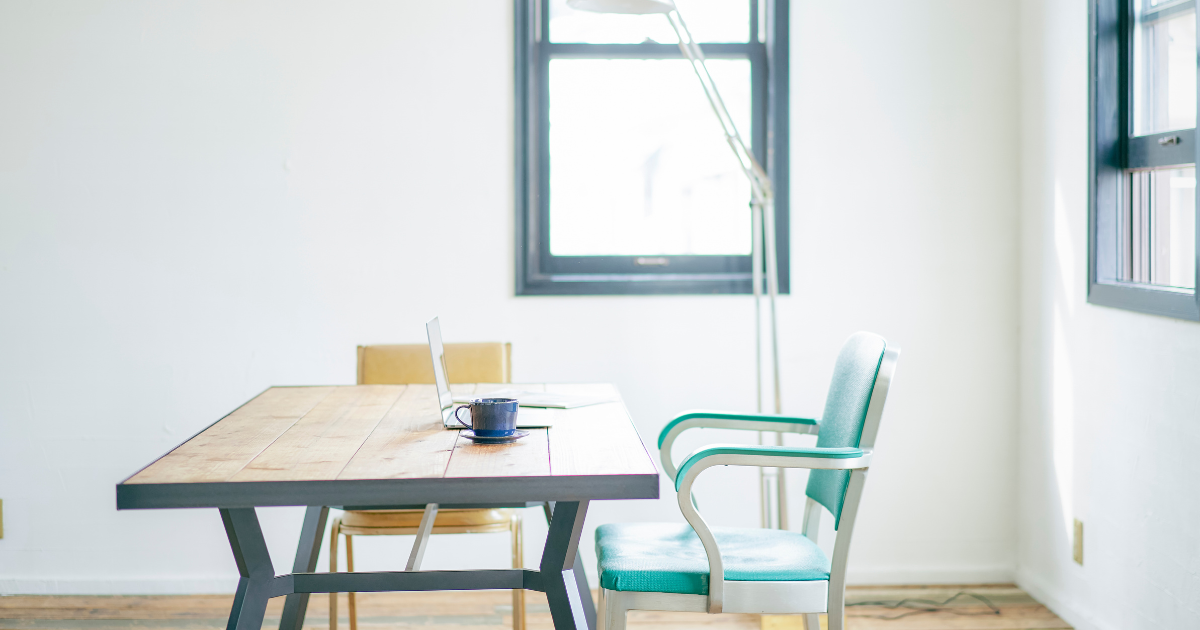 明るい日差しが差し込む、無人のテーブルと椅子