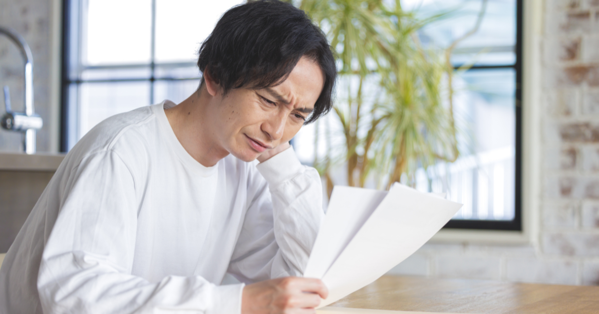 書類を手に持った男性が困っている様子