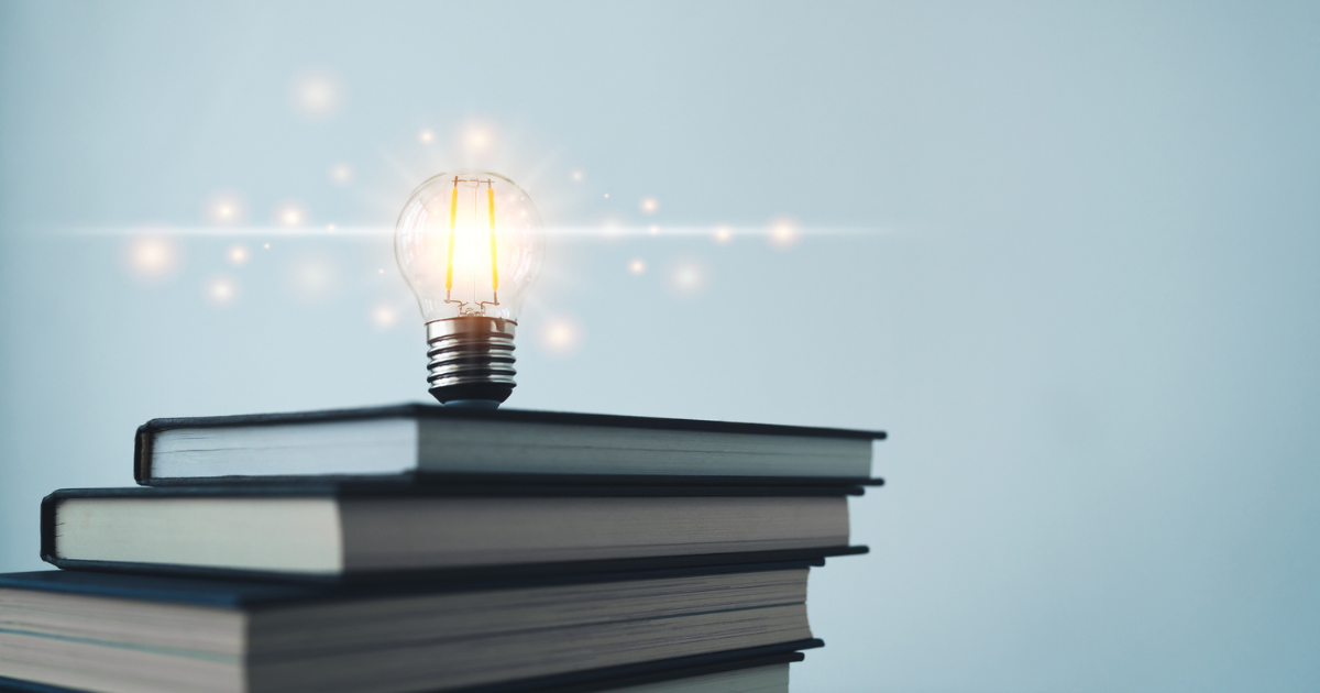 積み上げられた本の上で光る電球