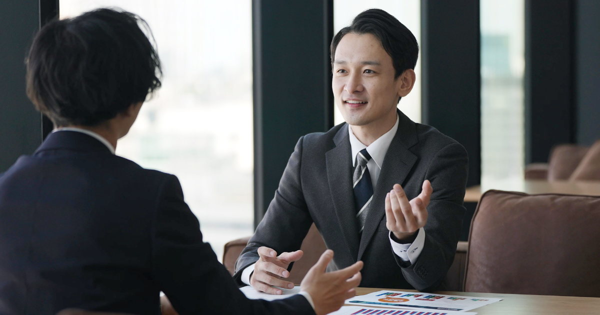向き合って打ち合わせをする2人のビジネスマン