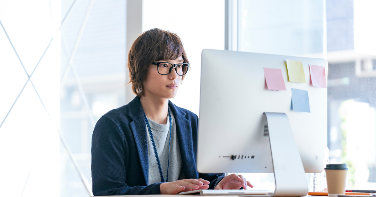 パソコンに向かって作業をしている男性