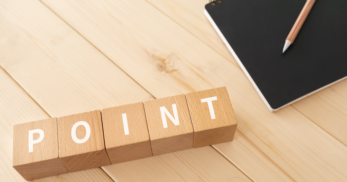 「POINT」と書かれた木のブロックと、横に置かれたペンとノート